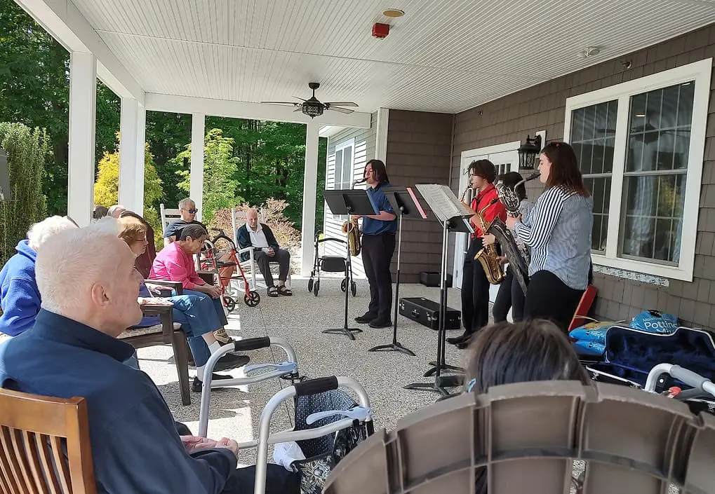 Beaver Lake Lodge Music Playing on Porch Band playing acoustic music on a porch for elderly residents