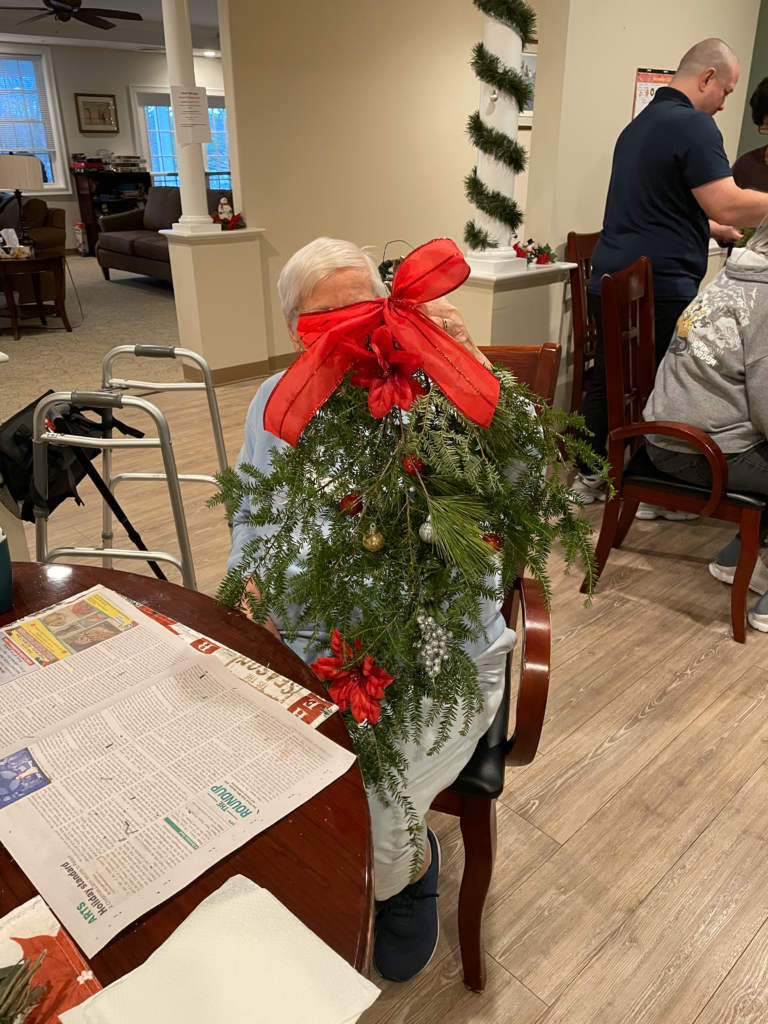 A resident is holding a wreath they made up for the camera.